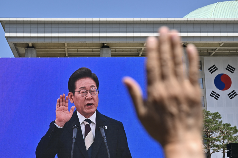 2025年6月4日,李在明於國會宣誓就職時,國會外聚集的支持者也舉手觀看就職典禮現場轉播。(攝影/Pedro Pardo/AFP)