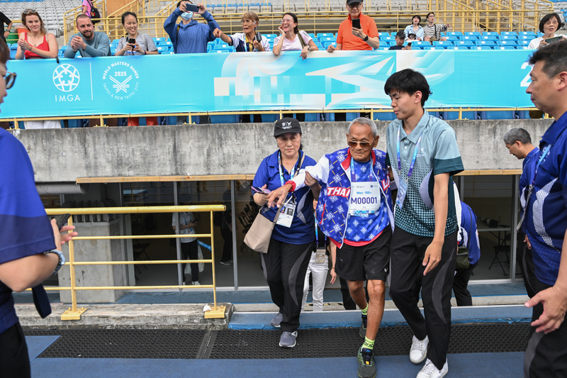 2025年雙北世界壯年運動會於5月21日下午舉行擲部鐵餅競賽,參加選手皆為75歲以上高齡選手,比賽結束後馬上進行頒獎儀式,圖中被攙扶的選手是105歲的泰國薩旺(Sawang Janpram)正要走往頒獎臺。(攝影/謝佩穎)