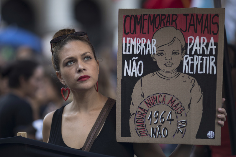 2019年,時任巴西總統的波索納洛(Jair Bolsonaro),要求國防部在3月31日當天,為被視爲獨裁統治起始的1964年軍事政變舉辦「適當紀念活動」,引起極大反彈。當天在里約熱內盧街頭的抗議隊伍中,一名抗議者舉著標語「不要慶祝,記得是為了不再重演。絕不再有獨裁。」(攝影/Leo Correa/AP Photo/達志影像)