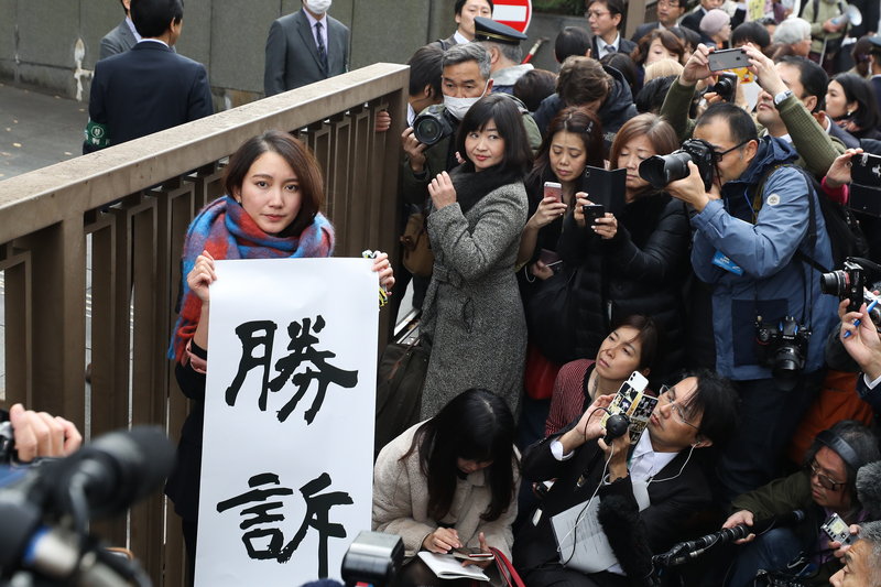 2019年12月18日於日本東京,記者伊藤詩織在東京地方法院前舉起象徵勝利的標語。東京法院當日裁定,針對伊藤詩織指控前電視台記者山口敬之性侵的案件,山口敬之須賠償330萬日圓(約3萬美元),此案被視為日本#MeToo運動重要里程碑之一。(攝影/Takashi Aoyama/Getty Images)