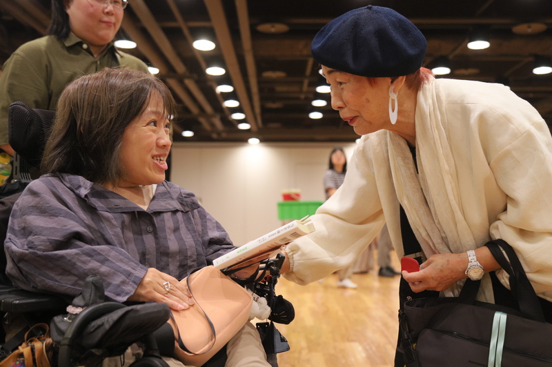 2025年6月11日，2025東亞性別平等論壇邀請上野千鶴子擔任講師，有一民眾遞書給她簽名。（圖片提供／婦權基金會）