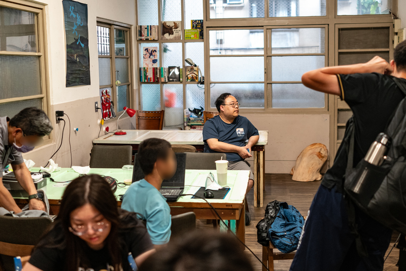 旗津醫院小兒科主治醫師周柏青,在咖黑咖啡二樓設置的活動空間裡與社工們一起陪伴與觀察來這裡的兒少和家長。(攝影/陳曉威)