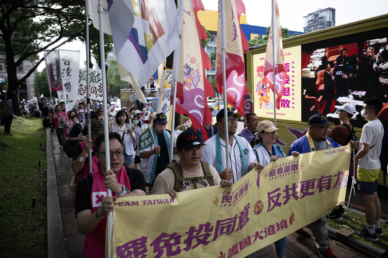 2025年7月12日,「護國大遶境」活動隊伍抵達台中,遊行隊伍旁的選傳車正在播放立法院議場內的畫面。(攝影/楊子磊)