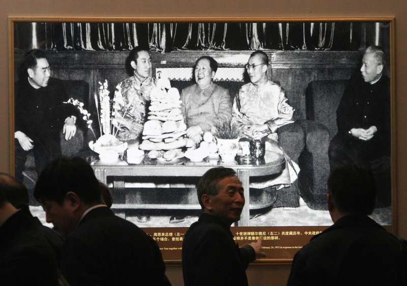 2009年3月18日，中國官方舉辦「西藏民主改革50週年」主題展覽，展覽中一張攝於1955年照片呈現中國國家主席毛澤東（中）與第十四世達賴喇嘛（右2）、第十世班禪喇嘛（左2）並坐。（攝影／David Gray／REUTERS／達志影像）