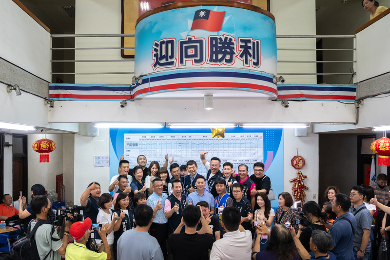 7月26日,台中國民黨3位立委罷免案全獲否決,黨部內工作人員開心合照。(攝影/謝佩穎)