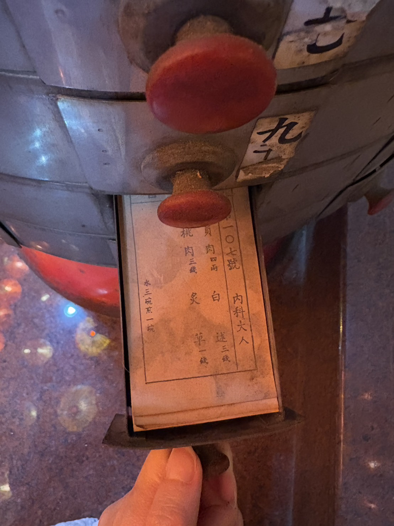 台南保華宮藥籤桶,方格內的粉紅籤單已經受潮且積滿灰塵。(攝影/鍾侑芸)