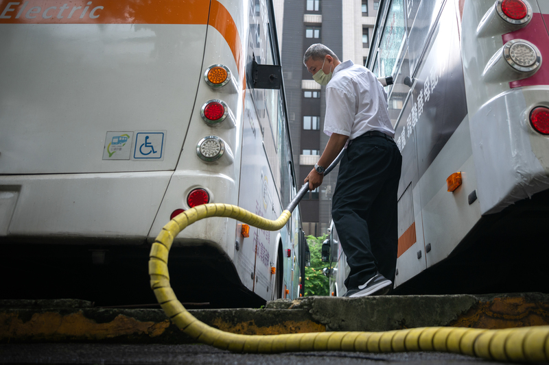 公車電動化最困難的部分是要將調度站改為充電站，需要將充電時間與空間納入考量。圖為首都客運292路線公車，一名駕駛員正準備為公車充電，這是他每趟行程結束後的例行公事。（攝影／謝佩穎）