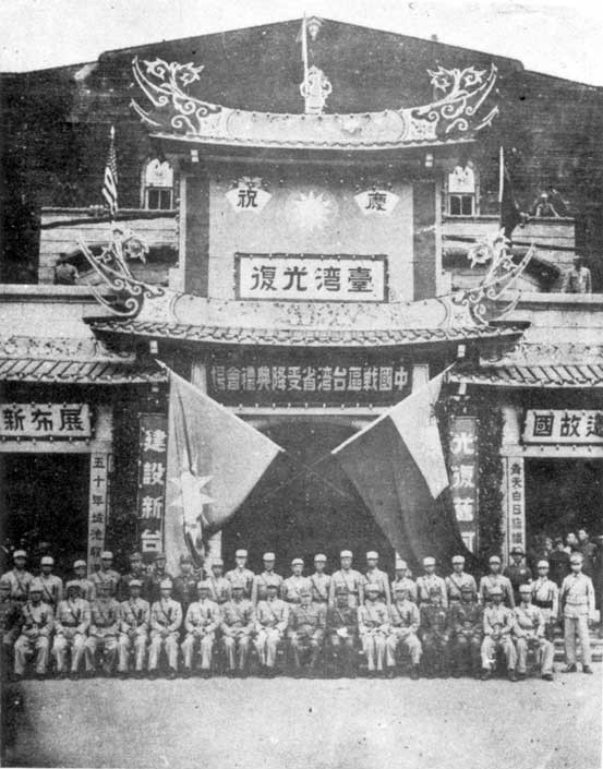 1945年10月25日,台北公會堂舉行「中國戰區台灣省受降典禮」後,台灣省警備總司令部全體官兵合影。左半邊掛中國國民黨黨旗,右半邊掛中華民國國旗。(照片來源/公有領域/Wikimedia Commons)