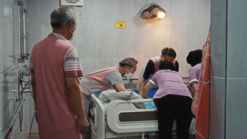 蔡螺多觀察，老一輩的韓國人對簽署安寧緩和醫療的接受度漸漸提升。圖為安寧病房照顧服務員與志工協力替臥床患者沐浴。（劇照提供／EBS）