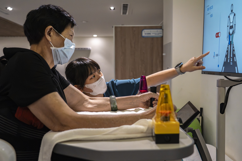 烏日青松住宿長照機構旁邊規劃了診所,面對社區開放,也方便住民就診。圖為物理治療師協助阿媽進行腿部行走的復健。(攝影/陳曉威)