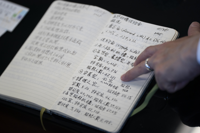 衛福部次長呂建德隨身攜帶筆記本，將長照各項重要數據記下，清楚計算出目前住宿型機構還缺多少床位。（攝影／陳曉威）