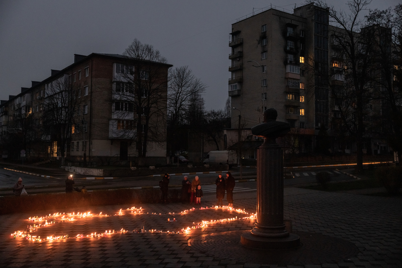 2023年3月31日，適逢從俄軍占領後重奪布查（Bucha）一週年紀念日，在當地的沃克扎爾納街（Vokzal'na Street），人們站在用蠟燭拼成的烏克蘭地圖旁，悼念在俄羅斯占領期間的遇難者。（攝影／Roman Pilipey／Getty Images）