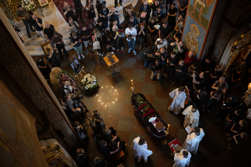 2025年8月8日，基輔的聖米迦勒金頂修道院，神父們在烏克蘭記者羅什奇娜（Viktoriia Roshchyna）的棺木旁舉行告別儀式。羅什奇娜於2023年夏季在俄羅斯占領的札波黎沙（Zaporizhzhia）工作時被俘。她於2024年10月在俄羅斯監獄中死亡，遺體被運回烏克蘭後，驗屍發現身上有多處遭受酷刑的痕跡。（攝影／Yan Dobronosov／Global Images Ukraine via Getty Images）