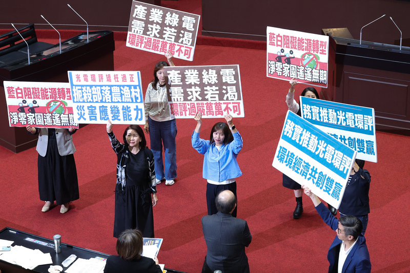 2025年11月14日下午，立法院針對《環境影響評估法》修正草案進行朝野協商，民進黨立委拿著各式手舉牌表達反對意見。（攝影／翁睿坤／中央社）