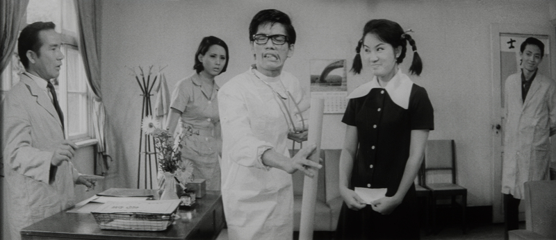 《張帝找阿珠》中的醫院院長（康丁飾）在阿珠（楊麗花飾）面前以歌仔戲表演方式比劃。（圖片提供／國家影視聽中心）