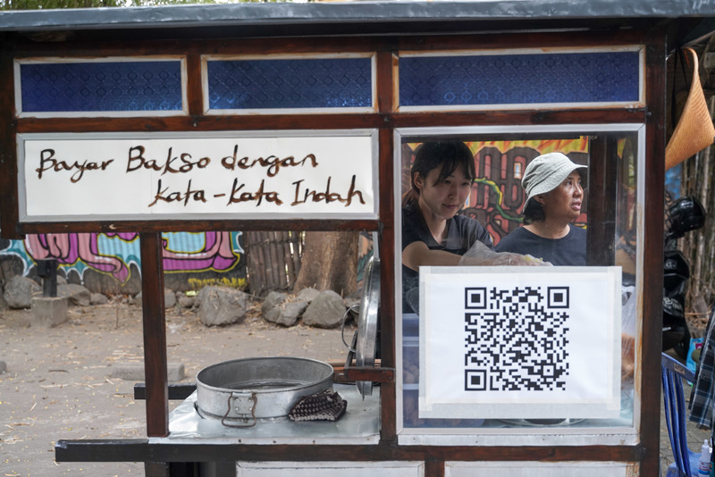 Shooshie Sulaiman與Ayaka Yoshida推著攤車，邀請觀眾「用美麗的印尼語支付肉丸」。（照片提供／日惹雙年展基金會）