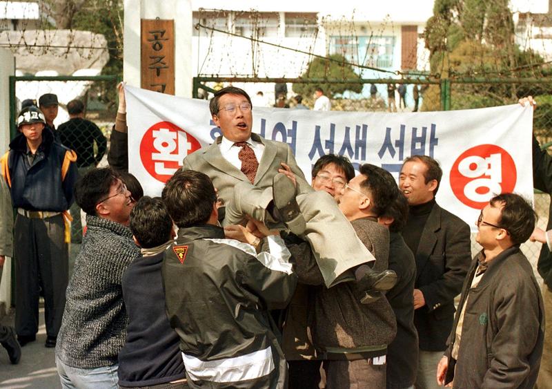 黃晳暎因未經授權前往北韓而於1993年入獄，後經總統金大中特赦，1998年3月13日，自公州監獄獲釋後，被朋友與支持者高舉拋向空中慶祝。（攝影／KIM Jae-Hwan／AFP）