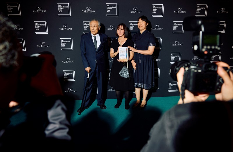 2024年5月21日，黃晳暎（左）在倫敦舉行的2024年國際布克獎頒獎典禮紅毯上，與其著作《日暮時分》譯者Sora Kim-Russell（中）、Youngjae Josephine Bae（右）合影。（攝影／BENJAMIN CREMEL／AFP）