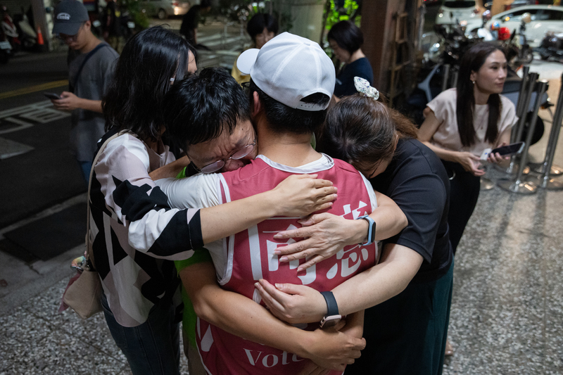 2025年7月26日，罷免投票結果不如預期，支持罷免的公民團體志工在辦公室外落淚擁抱。（攝影／謝佩穎）