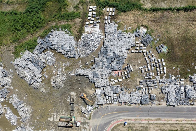 2025年8月14日，新塭滯洪池。丹娜絲風災後，光電業者調派大量人力，將受損的光電設施打撈上岸，並分為塑膠浮台、光電板及電線，委託不同的回收業者進行處理。（攝影／謝佩穎）