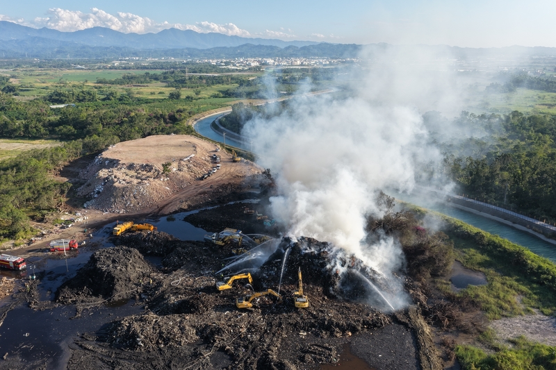 丹娜絲風災產生大量廢棄物，光電板以外的木材、營建廢棄物等暫置在垃圾掩埋場難以去化，因產生沼氣而不時發生火災事故。圖為2025年12月2日悶燒中的烏樹林營區暫置垃圾場，近兩週仍無法撲滅，造成嚴重的空汙危害。（攝影／謝佩穎）