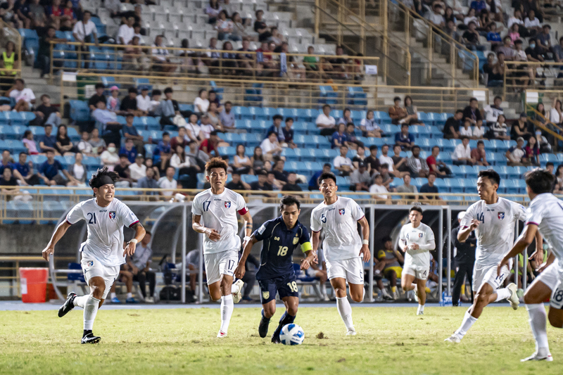2025年10月14日，2027亞足聯亞洲盃資格賽最終輪，台灣男足於台北田徑場主場迎戰泰國。台灣隊上半場以0比3落後，雖然下半場開場不久攻下全隊唯一進球，但最終仍以1比6落敗，分組4連敗墊底遭淘汰。圖為下半場，號稱「泰國梅西」的泰國隊隊長頌甲辛（Chanathip Songkrasin）突破台灣球員封阻，帶球衝向球門禁區。（攝影／陳曉威）