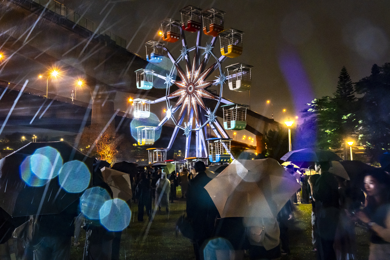 2025年10月1日，2025台北白晝之夜於圓山景觀公園舉行開幕式，吸引民眾欣賞裝置藝術與互動作品，活動以圓山地區為核心場域延伸至周邊文化據點。圖為藝術家姚仲涵以《光電獸#45－請支援收音》為題，將位於圓山兒童樂園舊址的摩天輪轉化成巨大的互動聲光裝置，吸引許多民眾在雨中前往欣賞。（攝影／陳曉威）