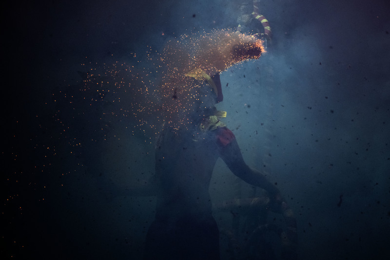 2025年2月元宵節前夕，台東玄武堂前連日舉辦盛大炸寒單活動，一枚點燃爆竹飛向肉身寒單，即將引爆。在民俗信仰裡炮炸是辟邪、求財象徵，代價卻是肉身寒單的皮肉傷。（攝影／楊子磊）