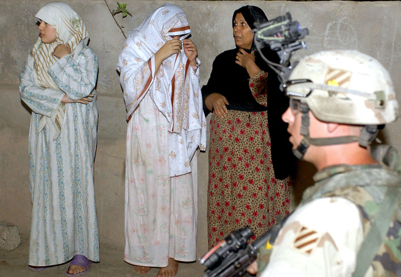 恩洛認為寫作者的任務也包括要持續對讀者說：「我們可以呈現部分真相，但這還不是故事的結局，親愛的讀者，你們要繼續尋找其他的線索。」圖為2005年10月5日，在伊拉克提克里特（Tikrit），一名美軍士兵在戰友進行夜間突襲時，負責看守當地婦女。（攝影／Tauseef Mustafa ／AFP）