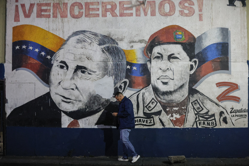 2026年1月3日，隨著美軍對委內瑞拉發動空襲後，一名男子行經卡拉卡斯街頭，其身後的壁畫繪有俄羅斯總統普丁（Vladimir Putin）與委內瑞拉前總統查維茲（Hugo Chávez）的畫像。川普政府之所以採取強硬行動，主因之一即是無法忽視馬杜洛政權與俄羅斯日益緊密的戰略結盟。（攝影／Pedro Rances Mattey／ANADOLU via AFP）