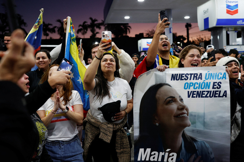 2026年1月3日，邁阿密的委內瑞拉僑民得知美軍突襲成功後上街慶祝。圖中婦女高舉反對派領袖馬查多（María Corina Machado）的肖像，馬查多為2025年諾貝爾和平獎得主，曾遭馬杜洛政府政治迫害。（攝影／Marco Bello／Reuters／達志影像）