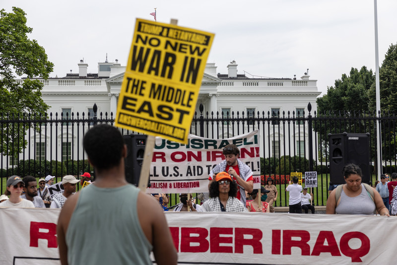 2025年6月22日，民眾在美國華盛頓特區的白宮外舉辦反戰集會，譴責美國對伊朗核設施的空襲，其中一位示威者手持寫有「中東不要新戰爭」的反戰標語。（攝影／Probal Rashid／LightRocket via Getty Images）