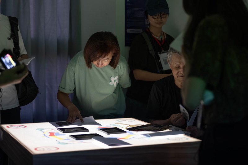 《情事絕品 feat.北屯社宅》透過特製的幾何圖騰桌遊，邀請參與者在發光桌前重組老照片與生命故事。（圖片提供／好伴社計）