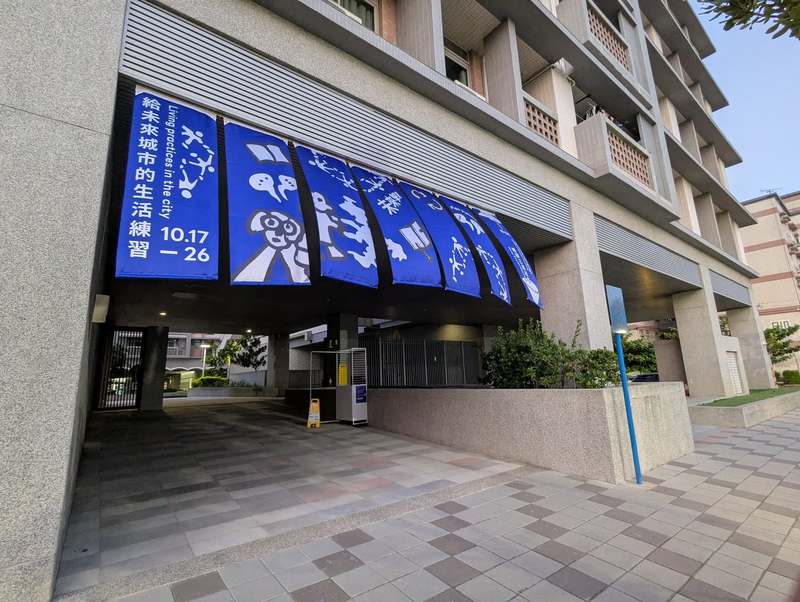 位於台中海線的梧棲社宅展區，策展團隊利用半戶外的穿廊空間懸掛展覽主視覺，將藝術氣息帶入居民的日常動線之中。（圖片提供／好伴社計）