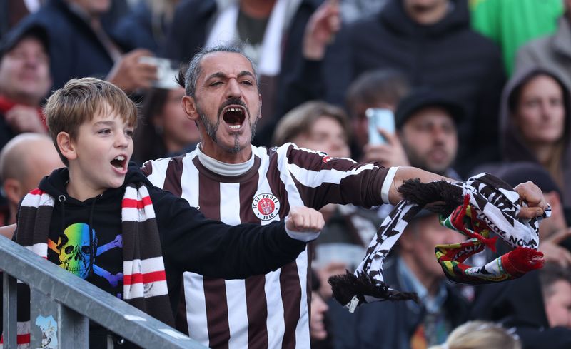 2025年9月27日，在德國漢堡的德甲聯賽上，聖保利對上強敵勒沃庫森（Bayer Leverkusen），比賽期間一名聖保利球迷帶領年輕球迷為球隊加油。（攝影／Stuart Franklin／Getty Images）