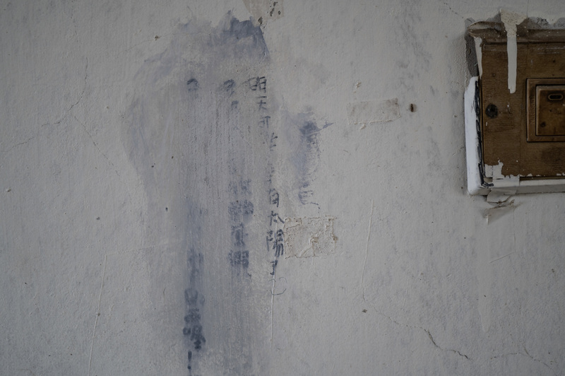 台南市學甲區一處民宅的牆面上有著模糊的手寫字跡，上頭寫著「明天可能會有太陽了」。（攝影／楊子磊）