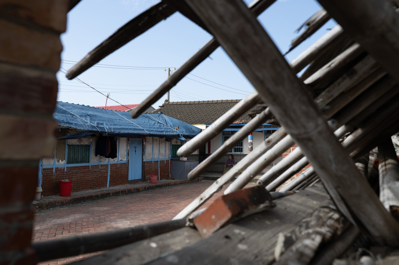 2026年1月30日，台南市學甲區一處民宅的屋頂仍覆蓋著殘破的帆布。（攝影／楊子磊）