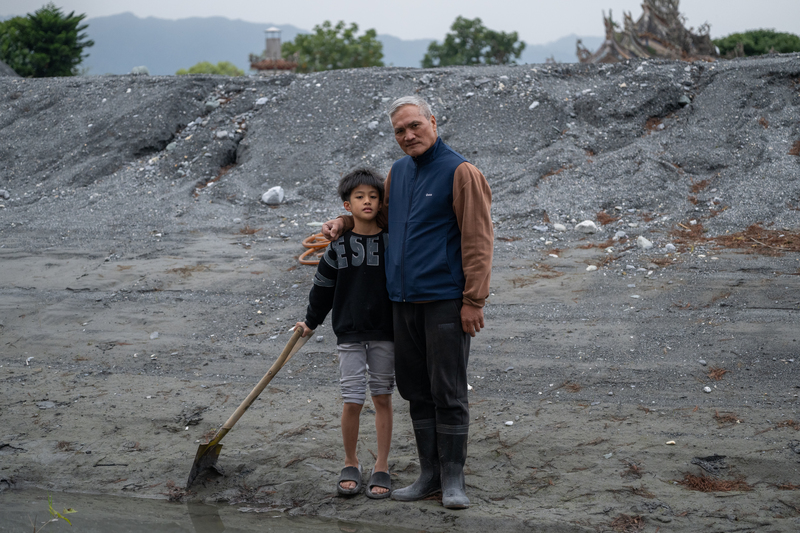 「拖鞋阿公」蘇建昌與他的孫子。蘇建昌說,災民對來到光復幫忙的鏟子超人們充滿感激,「我們真的無以回報。」他說,如果災民能好好振作、從絕望中站起來,也許就是對鏟子超人們最大的感謝。(攝影/謝佩穎)