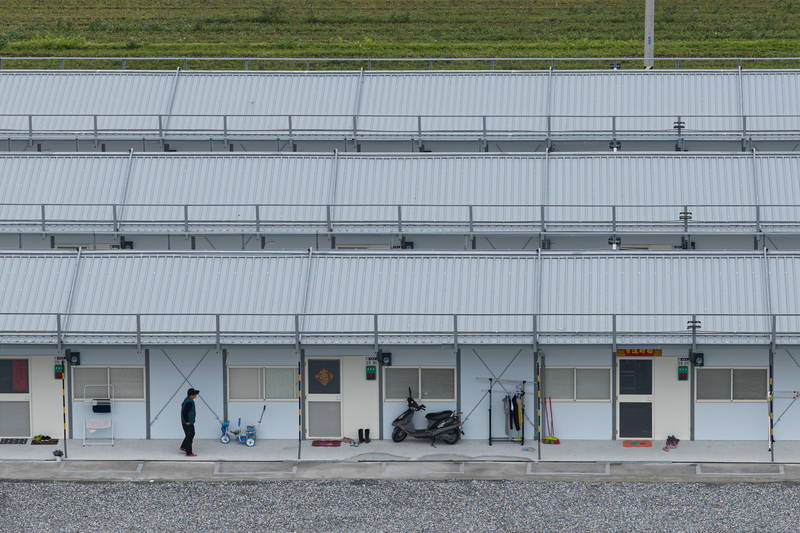 中繼屋建置於光復糖廠後方農地,外觀如同簡易的工寮,卻是災民們未來兩年安身立命的所在。目前約有10多戶居民入住,他們貼上春聯、迎接新年。(攝影/謝佩穎)