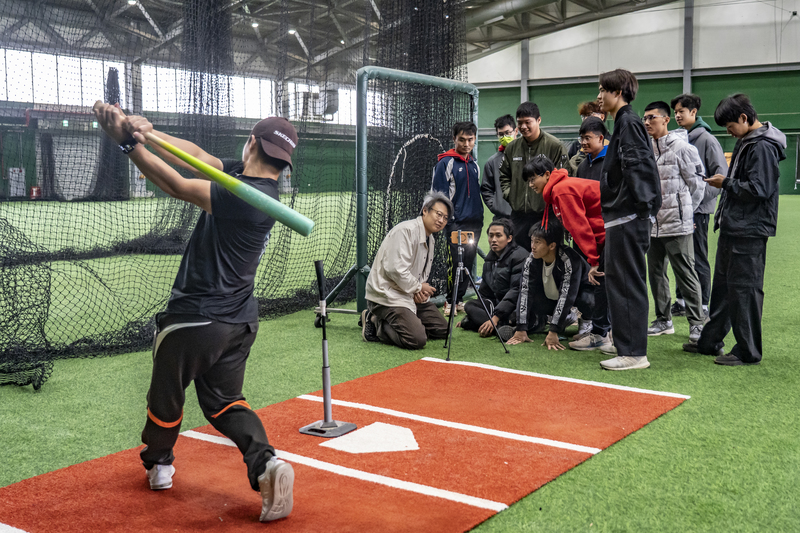 傳接球實驗室執行長關仲鈞（前排左蹲者）與成功大學棒球隊合作，由總教練彭怡千示範揮棒，讓學生認識棒球科學化訓練與數據收集。（攝影／陳曉威）
