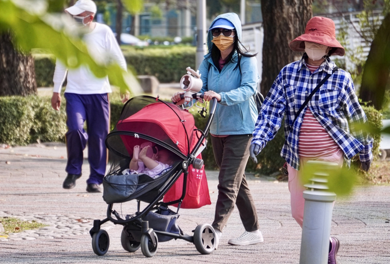 為減輕家庭育兒負擔,行政院日前宣布放寬外籍幫傭申請條件,但也引發外界對於是否將照顧責任回歸私有市場、托育公共化倒退等討論。圖為高雄市民眾推著嬰兒車於公園散步。(攝影/董俊志/中央社)