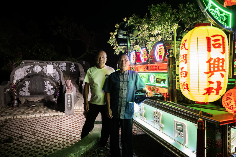 吳鵬飛（左）與吳飛熊是吳家來台定居的第四代，他們在南山公墓與自己的家族墓相鄰而居。吳飛熊現為同興社團長，陣頭所有鑼車、鼓亭的組裝則由吳鵬飛負責。（攝影／楊子磊）