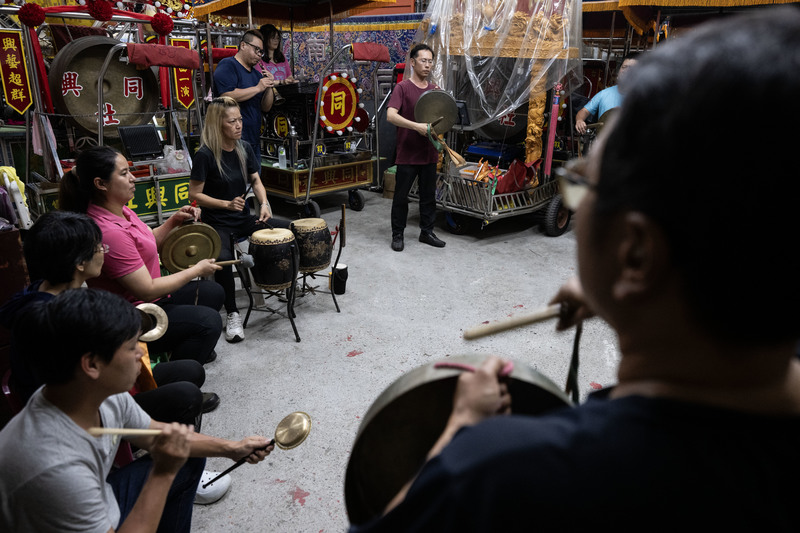 吳飛熊的女兒吳怡倩（左4）是家族第五代，如今接棒帶領同興社，他們每週都會在公墓旁的倉庫練團。（攝影／楊子磊）