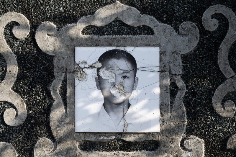 先人遺骨遷葬後，依照習俗敲碎墓碑與遺像。（攝影／楊子磊）