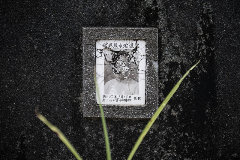 先人遺骨遷葬後，依照習俗敲碎墓碑與遺像。（攝影／楊子磊）