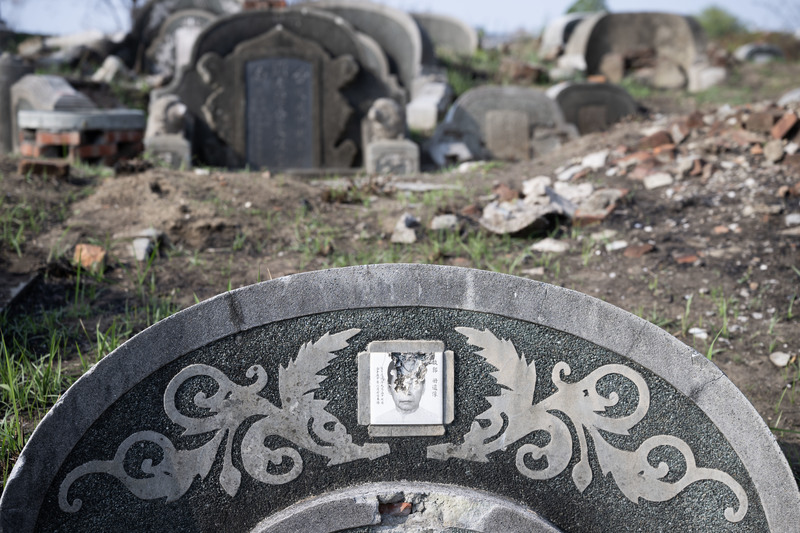 先人遺骨遷葬後，依照習俗敲碎墓碑與遺像。（攝影／楊子磊）