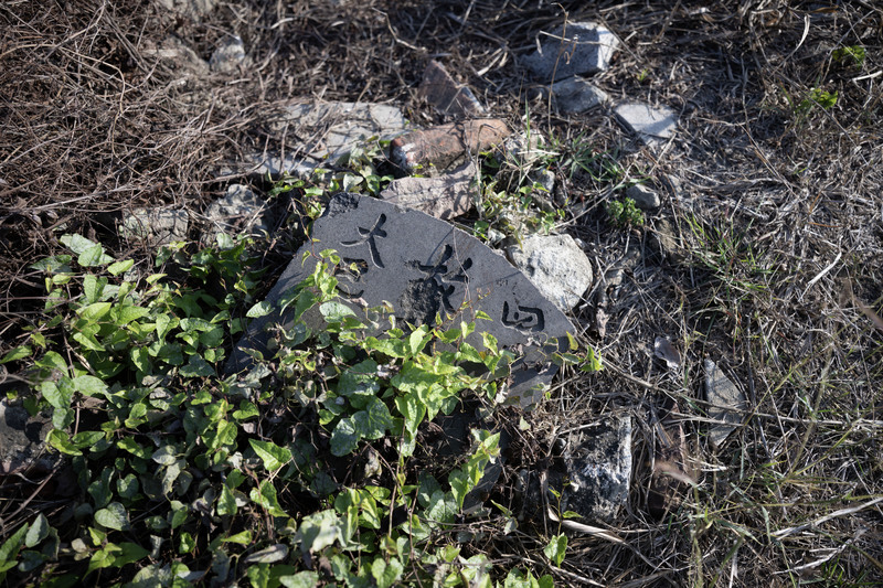 先人遺骨遷葬後，依照習俗敲碎墓碑與遺像。（攝影／楊子磊）
