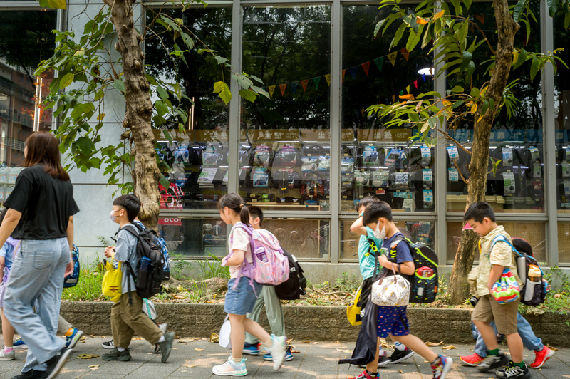 放學時分，孩童在安親班老師帶領下成群走過街頭。（攝影／黃世澤）