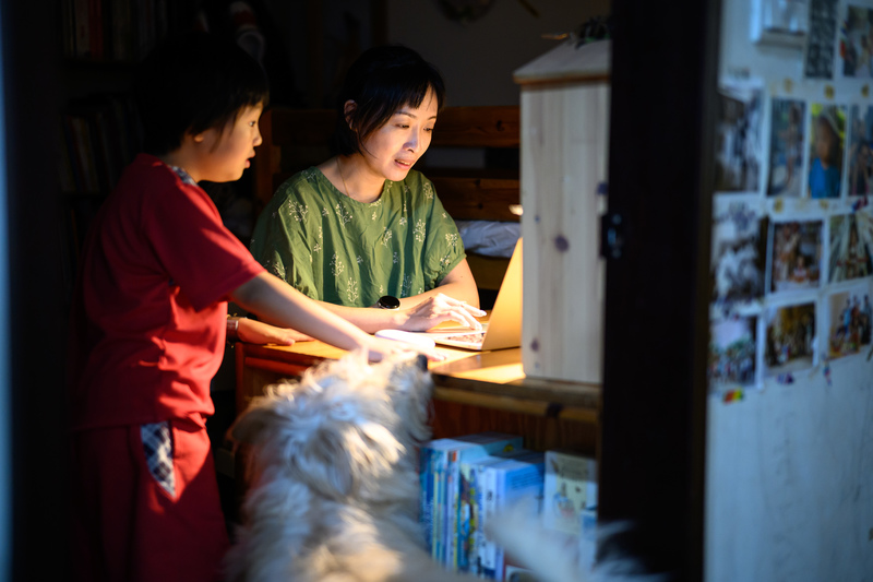 諶淑婷在工作與孩子間尋求平衡，一邊居家工作一邊回應孩子需求。在缺乏經濟資本外包勞務的情況下，面對育兒與長照的重疊壓力，「離開職場」可能成為中產世代在時間貧窮下的無聲選擇。（攝影／黃世澤）