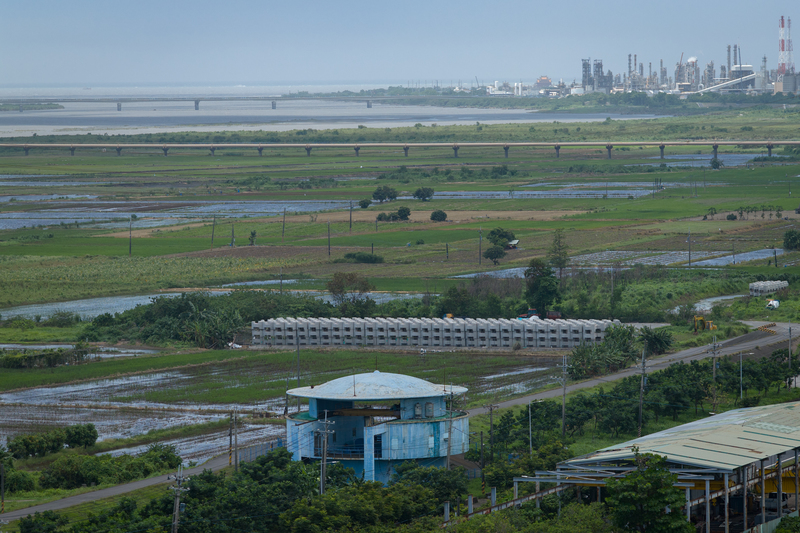 高屏溪流域範圍廣泛，圖下方藍色建築為昭明取水口，遠方為高屏溪口西岸的林園工業區，圖中間有一座水管橋（鵝黃色管線）連接高屏地區，作為跨河輸水用途。（攝影／謝佩穎）